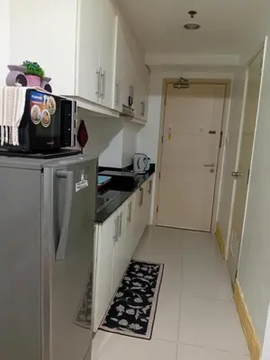 a small kitchen with a refrigerator and a microwave at Rdhee Condotel NEAR SMX MOA in Manila