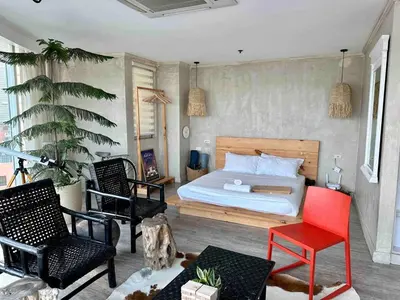 a bedroom with a bed and two chairs at 55-SQM The Urban Cabin in Poblacion Makati in Manila