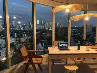 a laptop computer sitting on a table in front of a window at 55-SQM The Urban Cabin in Poblacion Makati in Manila