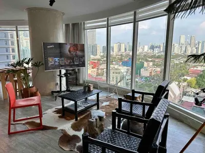 a living room with a view of a city at 55-SQM The Urban Cabin in Poblacion Makati in Manila