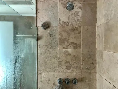 a shower with a glass door with a shower coil at 55-SQM The Urban Cabin in Poblacion Makati in Manila