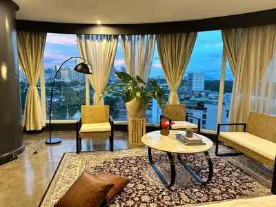 a living room with a table and a large window at 55-SQM Urban Cabin in Poblacion Makati in Manila