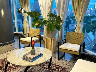 a room with chairs and a table and a window at 55-SQM Urban Cabin in Poblacion Makati in Manila