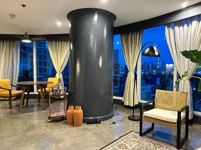 a living room with a large black boiler in front of a window at 55-SQM Urban Cabin in Poblacion Makati in Manila