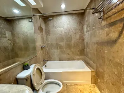 a bathroom with a toilet and a bath tub at 55-SQM Urban Cabin in Poblacion Makati in Manila