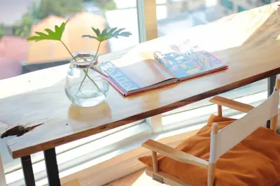a wooden table with a vase and a book and a vase at 55-SQM Stunning View Wood House Poblacion Makati in Manila