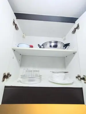 a kitchen with plates and a pot on a shelf at Affordable Condo Staycation at San Lorenzo place condominium in Manila