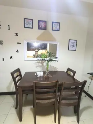 a dining room with a wooden table and chairs at Affordable Condo Staycation at San Lorenzo place condominium in Manila