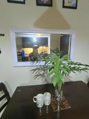 a table with a plant in a vase and two cups at Affordable Condo Staycation at San Lorenzo place condominium in Manila