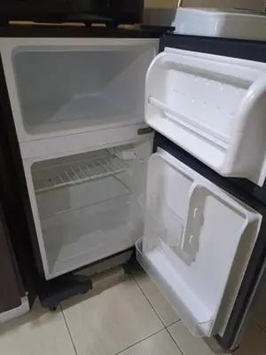 an empty refrigerator with its door open in a kitchen at Affordable Condo Staycation at San Lorenzo place condominium in Manila