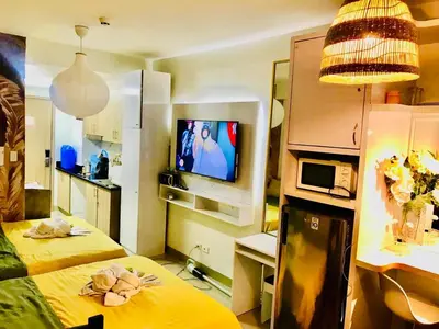 a small room with two beds and a television at Hotel De Rama Unit 5115 near MOA and NAIA in Manila