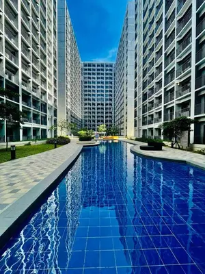 a large swimming pool in a city with tall buildings at Hotel De Rama Unit 5115 near MOA and NAIA in Manila