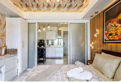 a living room with a bed and a kitchen at Homesweethome Beach Resort in Manila