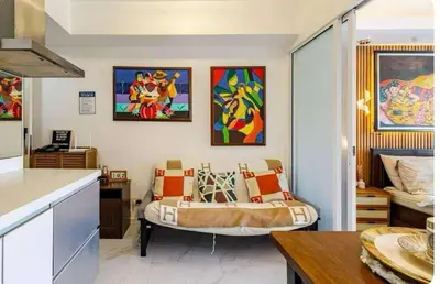 a living room with a couch and paintings on the wall at Homesweethome Beach Resort in Manila