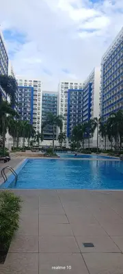a large swimming pool in a city with tall buildings at Sea Residences Jhayrose Staycation in Manila