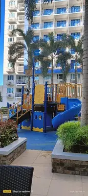 a playground in front of a large apartment building at Sea Residences Jhayrose Staycation in Manila