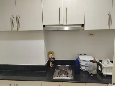 a kitchen with white cabinets and a counter top at Sea Residences, Pkwy, Pasay City 1300, Philippines in Manila