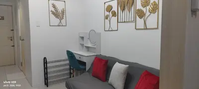 a living room with a couch and some pictures on the wall at Sea Residences, Pkwy, Pasay City 1300, Philippines in Manila