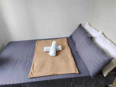 a bed with two rolled up towels on it at Sea Residences, Pkwy, Pasay City 1300, Philippines in Manila