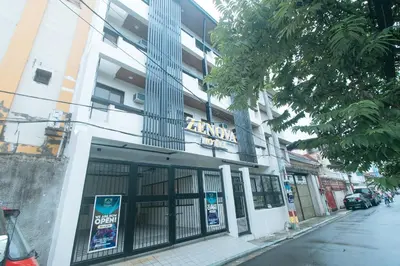 a building with a sign on the side of a street at RedDoorz at Zenova Hotel in Manila