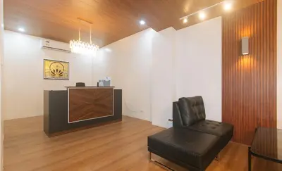 a living room with a chair and a television at RedDoorz at Zenova Hotel in Manila