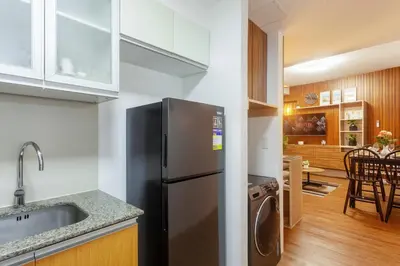 a kitchen with a stainless steel refrigerator and a dining room at Luxurious & Elegant Vibe in Newport City Pasay in Manila