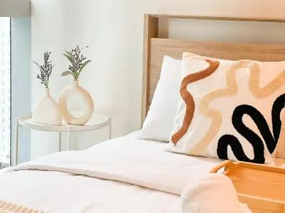a bedroom with a bed with two vases at Stylish 1BR Prime BGC Uptown near Hyatt #upt119c in Manila