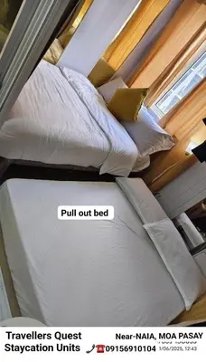 two beds in a room with avertisement for at Hotel De Rama Unit 1230 near MOA & NAIA in Manila