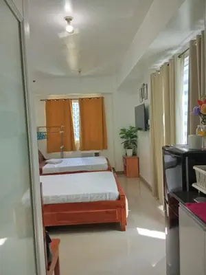 a bedroom with a bed and a tv in it at V&G Era Staycation in Manila