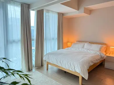 a bedroom with a bed and a large window at Uptown Suites in Manila