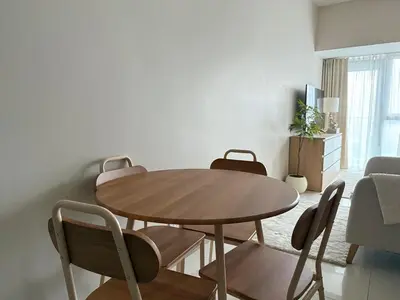 a dining room table and chairs in a living room at Uptown Suites in Manila
