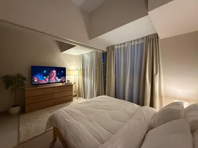 a bedroom with a bed and a flat screen tv at Uptown Suites in Manila