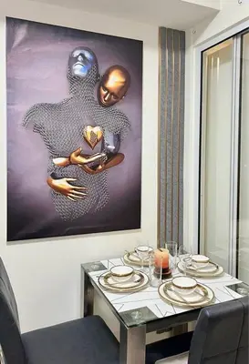 a dining room table with plates and a painting on the wall at Dream Escapade in Manila