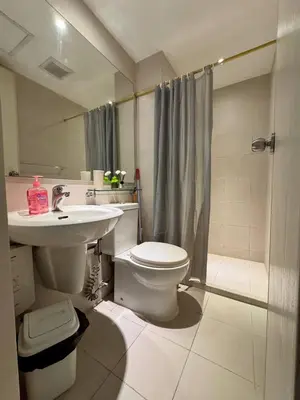 a bathroom with a toilet and a sink and a shower at Dream Escapade in Manila