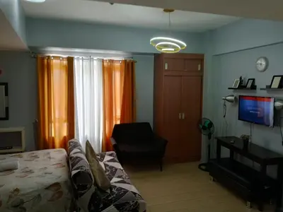 a living room with a couch and a chair and a television at Jentry condotel in Manila