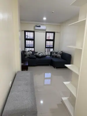 a living room with a blue couch and some shelves at 4 stores with rooftop in Manila