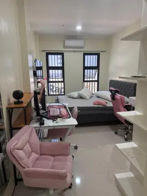 a room with a bed and a desk and chairs at 4 stores with rooftop in Manila