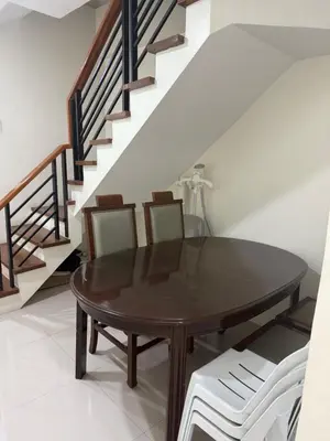 a dining room table with two chairs and a staircase at 4 stores with rooftop in Manila