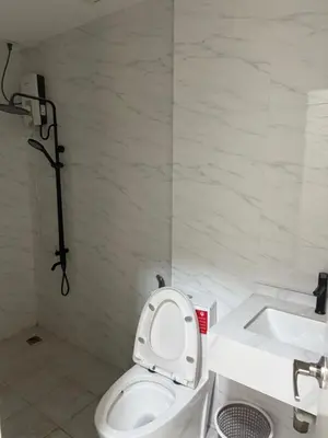 a white bathroom with a toilet and a sink at 4 stores with rooftop in Manila