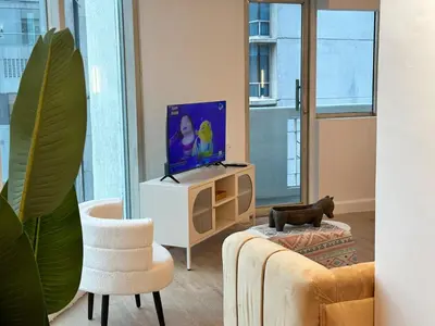 a living room with a tv and a couch at Chic Urban Stay with Balcony & Bathtub in Poblacion in Manila