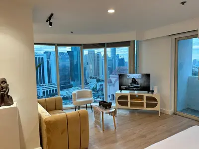 a living room with a couch and a tv at Chic Urban Stay with Balcony & Bathtub in Poblacion in Manila