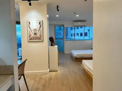a bedroom with a bed and a view of a building at Chic Urban Stay with Balcony & Bathtub in Poblacion in Manila