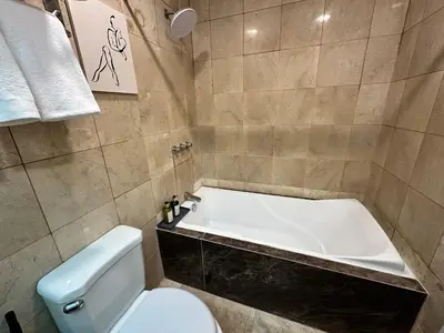 a bathroom with a bath tub and a toilet at Chic Urban Stay with Balcony & Bathtub in Poblacion in Manila