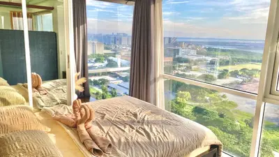 a bedroom with a large window with a view of the city at Stunning view staycation near MOA PICC WORLD TRADE CENTER AIRPORT LUNETA PARK MANILA OCEAN PARK QURINO GRANDSTAND in Manila