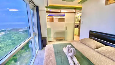 a room with a bed and a large window at Stunning view staycation near MOA PICC WORLD TRADE CENTER AIRPORT LUNETA PARK MANILA OCEAN PARK QURINO GRANDSTAND in Manila