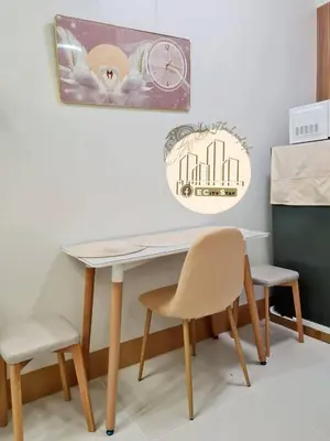 a dining room table with two chairs and a clock at EcityStay in Manila