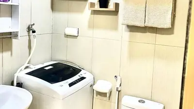a small bathroom with a toilet and a sink at Cozy accommodation near MOA AIRPORT WORLD TRADE AND PICC in Manila