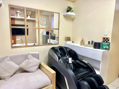 a living room with a chair and a mirror at Cozy accommodation near MOA AIRPORT WORLD TRADE AND PICC in Manila