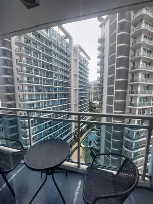 a balcony with chairs and a table and some buildings at Azure Bali Verde-1Bedroom pool view in Manila