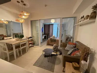 a living room with a dog sitting on a couch at Azure Bali Verde-1Bedroom pool view in Manila